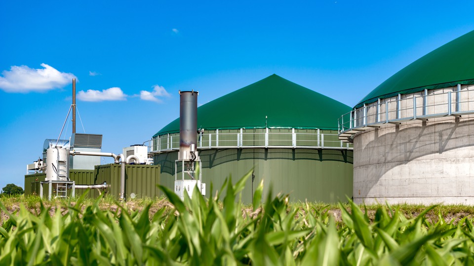 Biogas facility with green roof, blurred grass in the foreground.